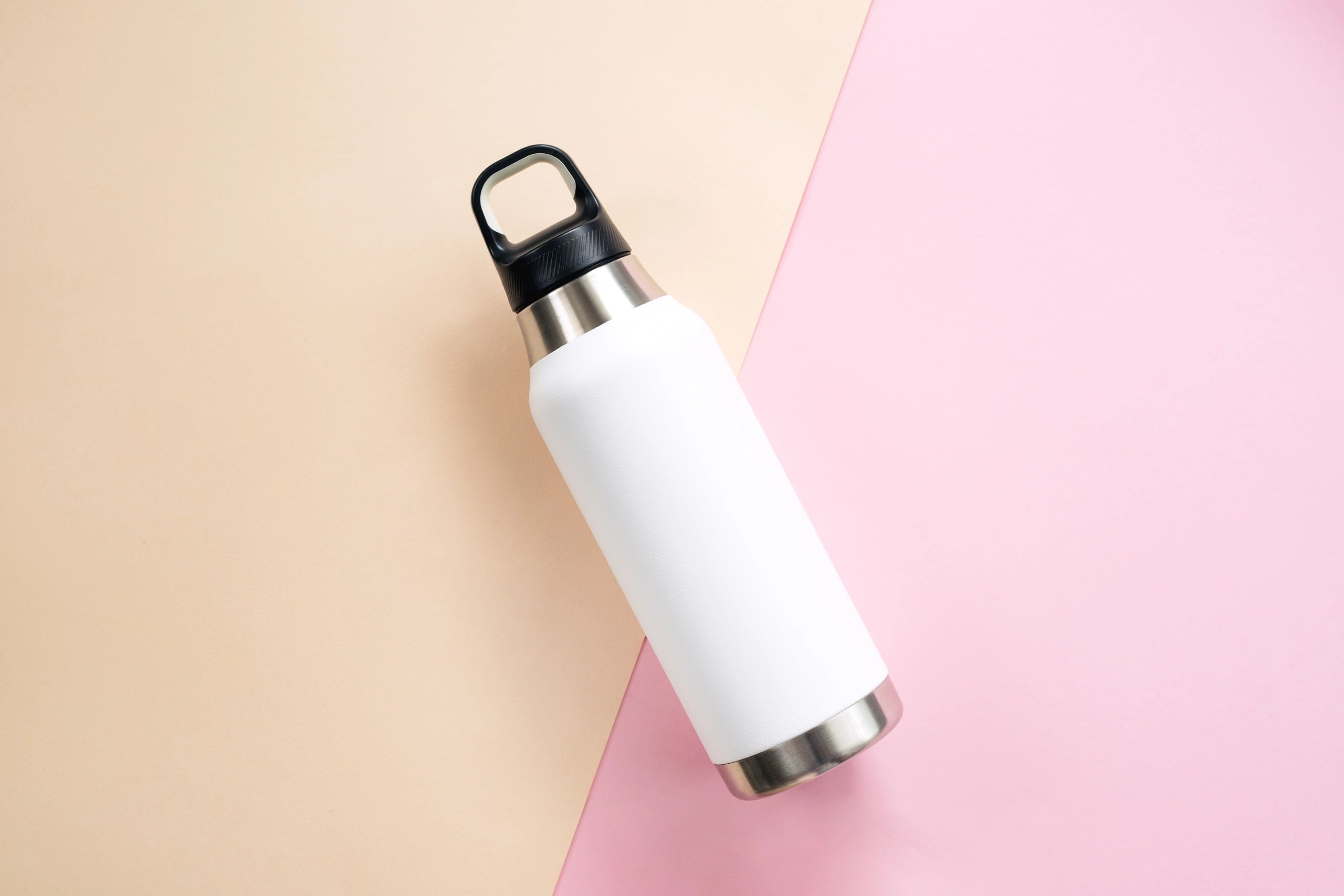 Reusable branded steel water bottle on table